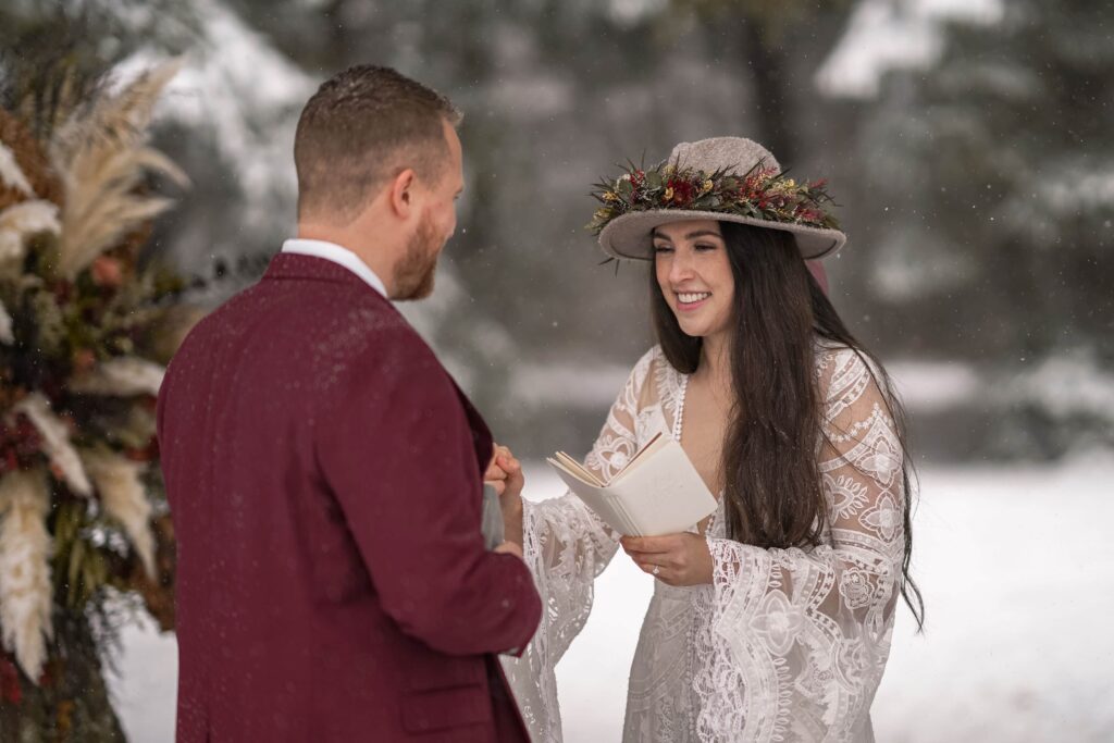 bride and groom reading vows in snowy forest in Hood River Oregon