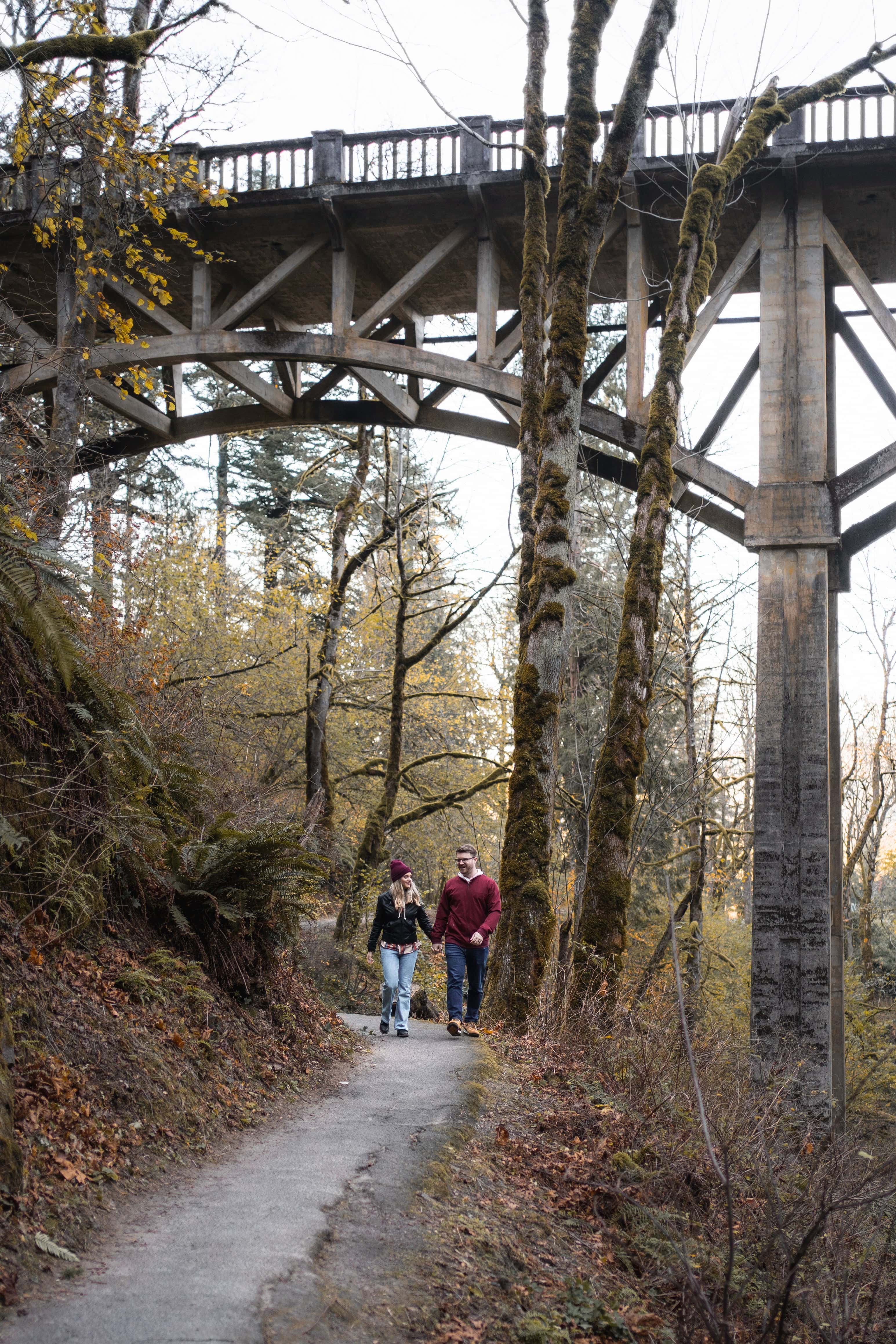 couple hiking on latourell Falls trail for engagement