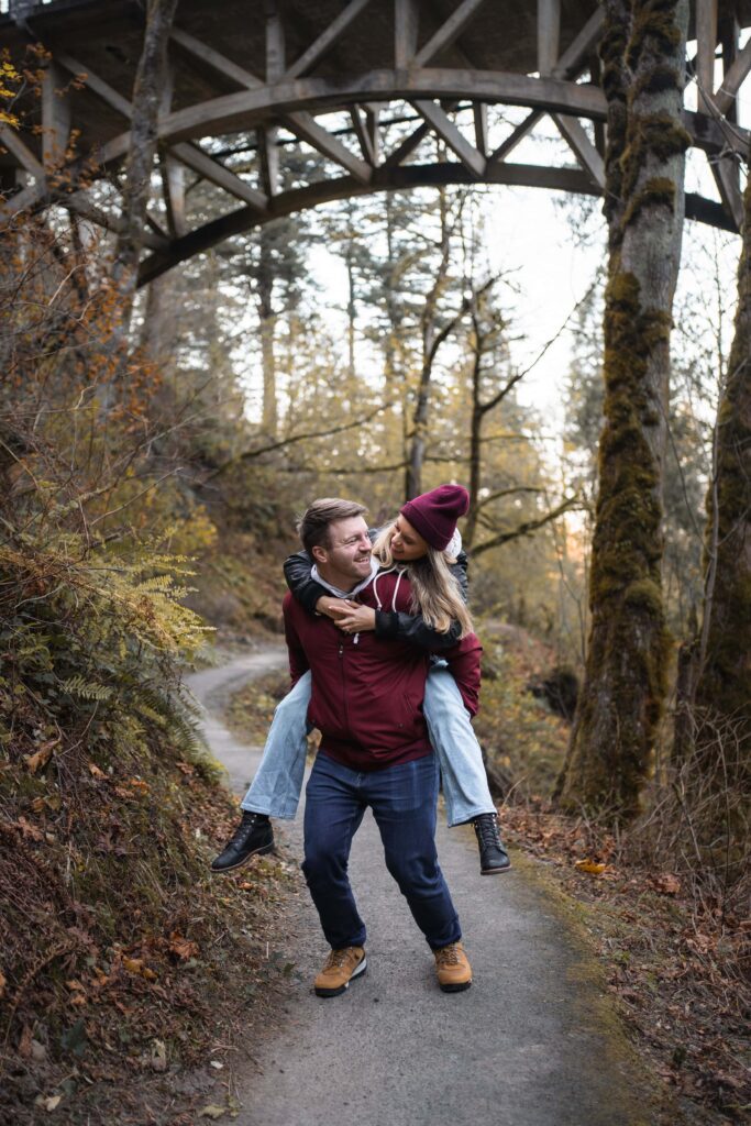 couple giving piggy back ride on trail in Columbia River Gorge