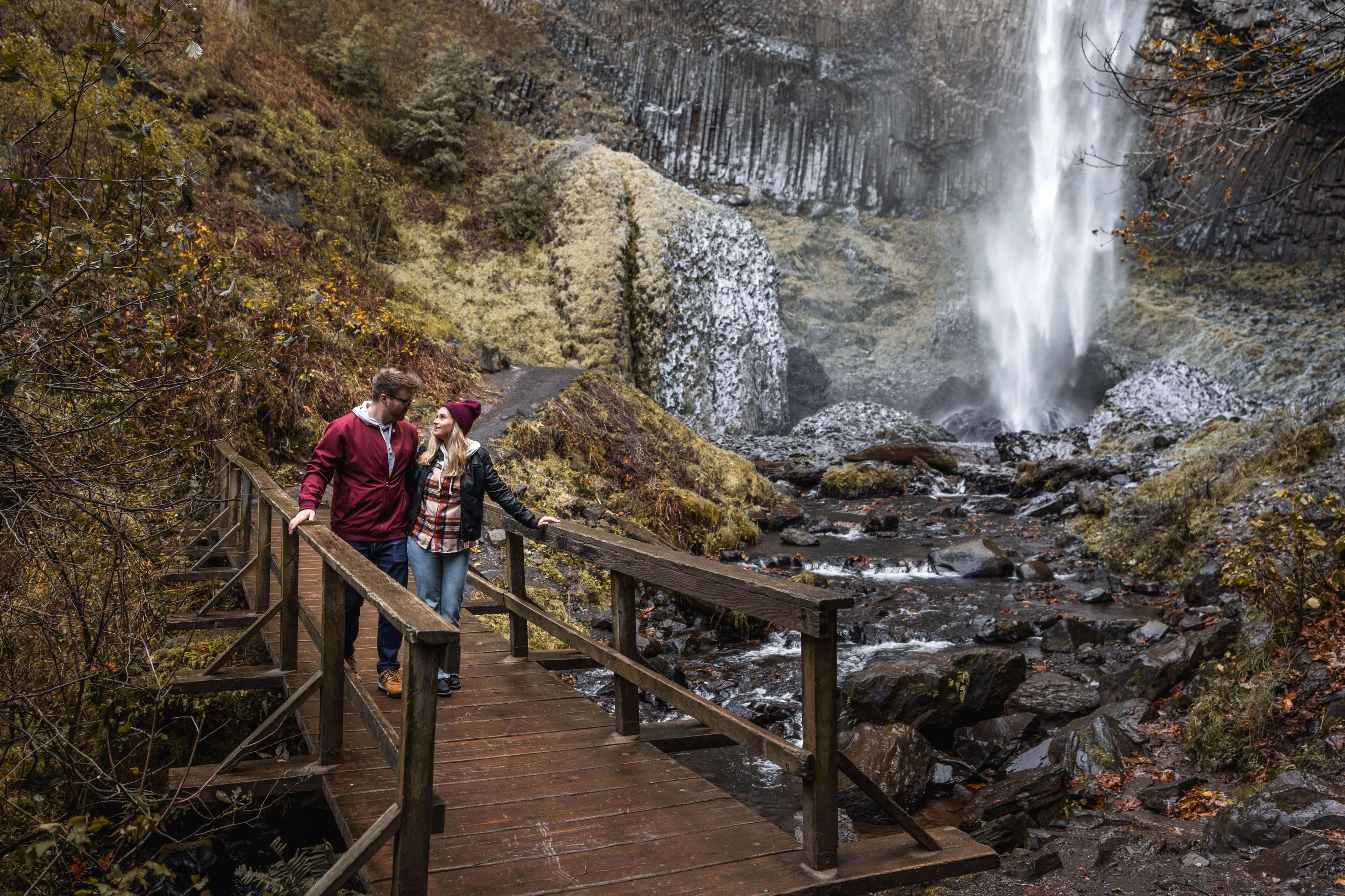 couple on bridge over river by Latourell Falls