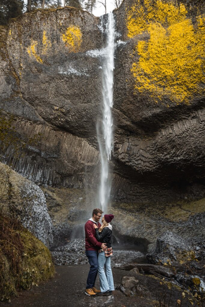 couple kissing under waterfall in oregon