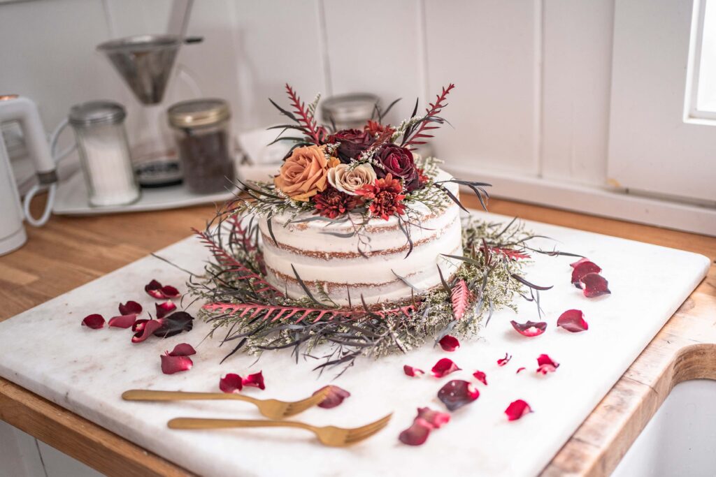 winter naked cake with red and orange rustic flowers