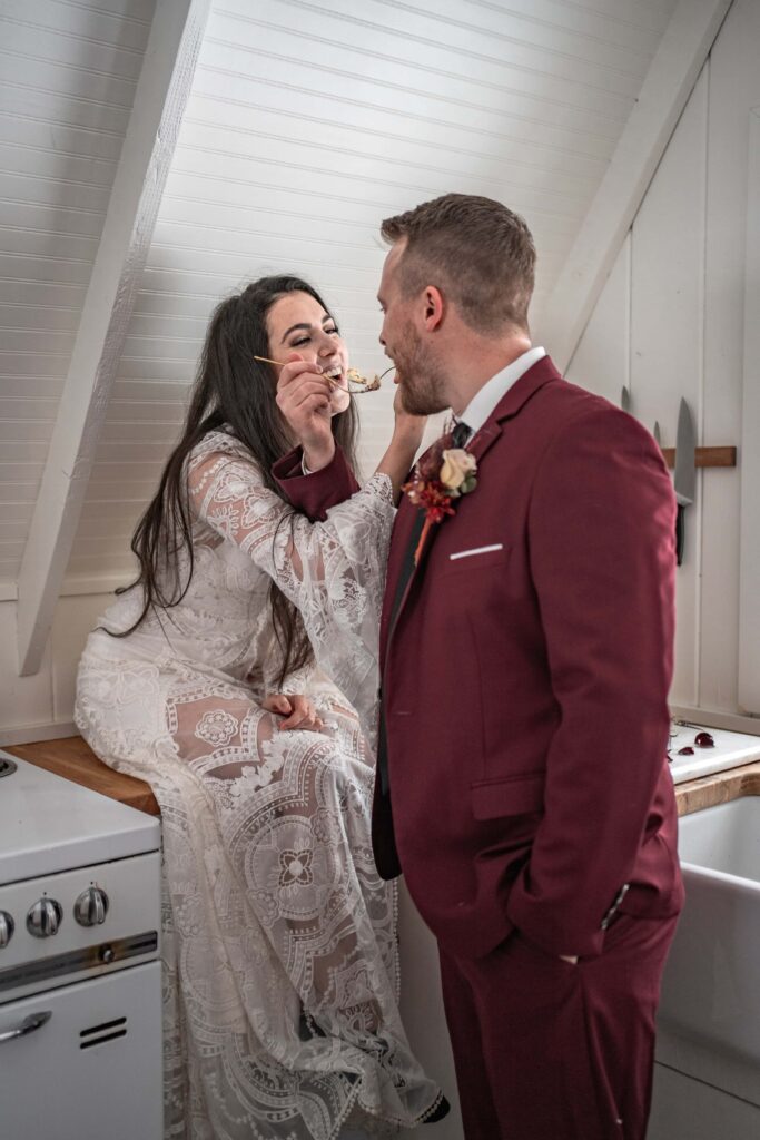 wedding couple eats cake in cabin elopement